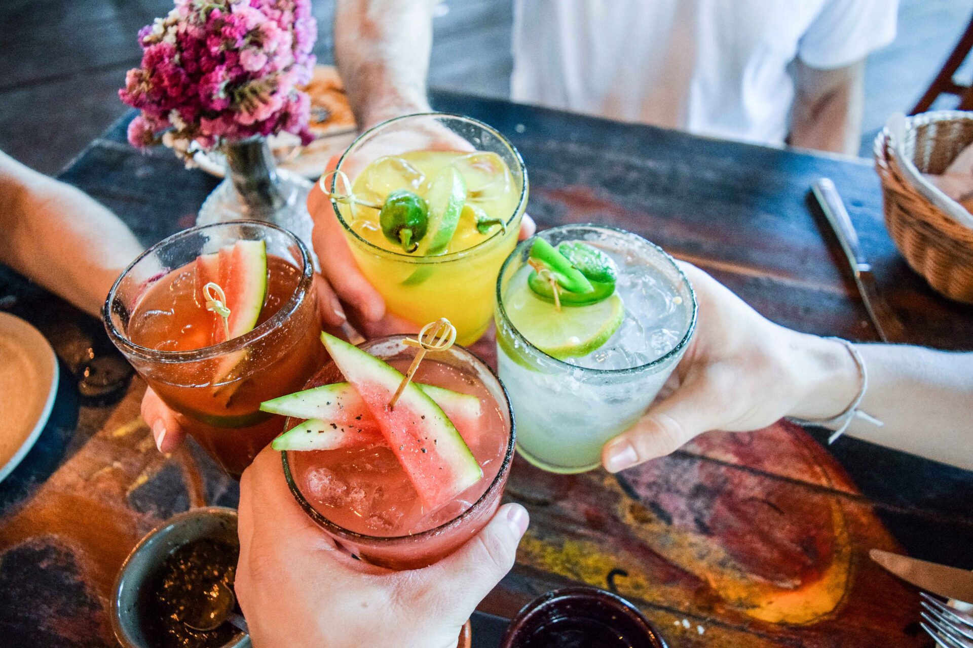 A group of people holding drinks at a table.