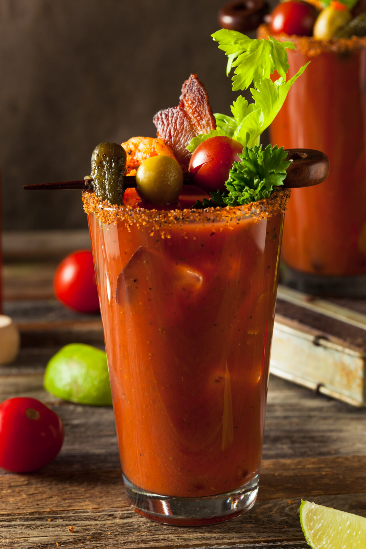 A bloody mary in a glass with garnishment and vegetables.